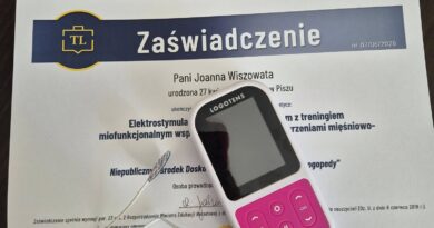 Zaświadczenie o ukończeniu kursu logopedycznego z elektrostymulacji leżące na biurku, obok bindowanego podręcznika i przenośnego elektrostymulatora Logotens z podłączonymi przewodami.