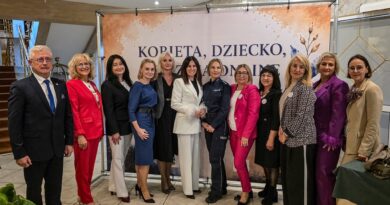 Grupa kobiet i mężczyzn pozuje do zdjęcia.