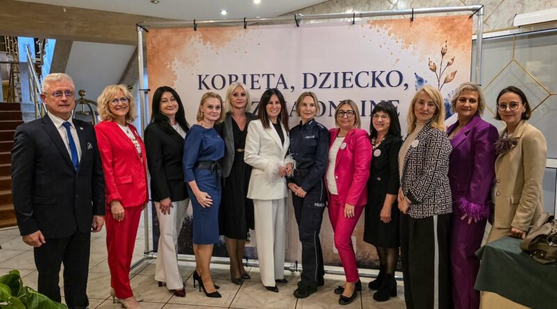 Grupa kobiet i mężczyzn pozuje do zdjęcia.